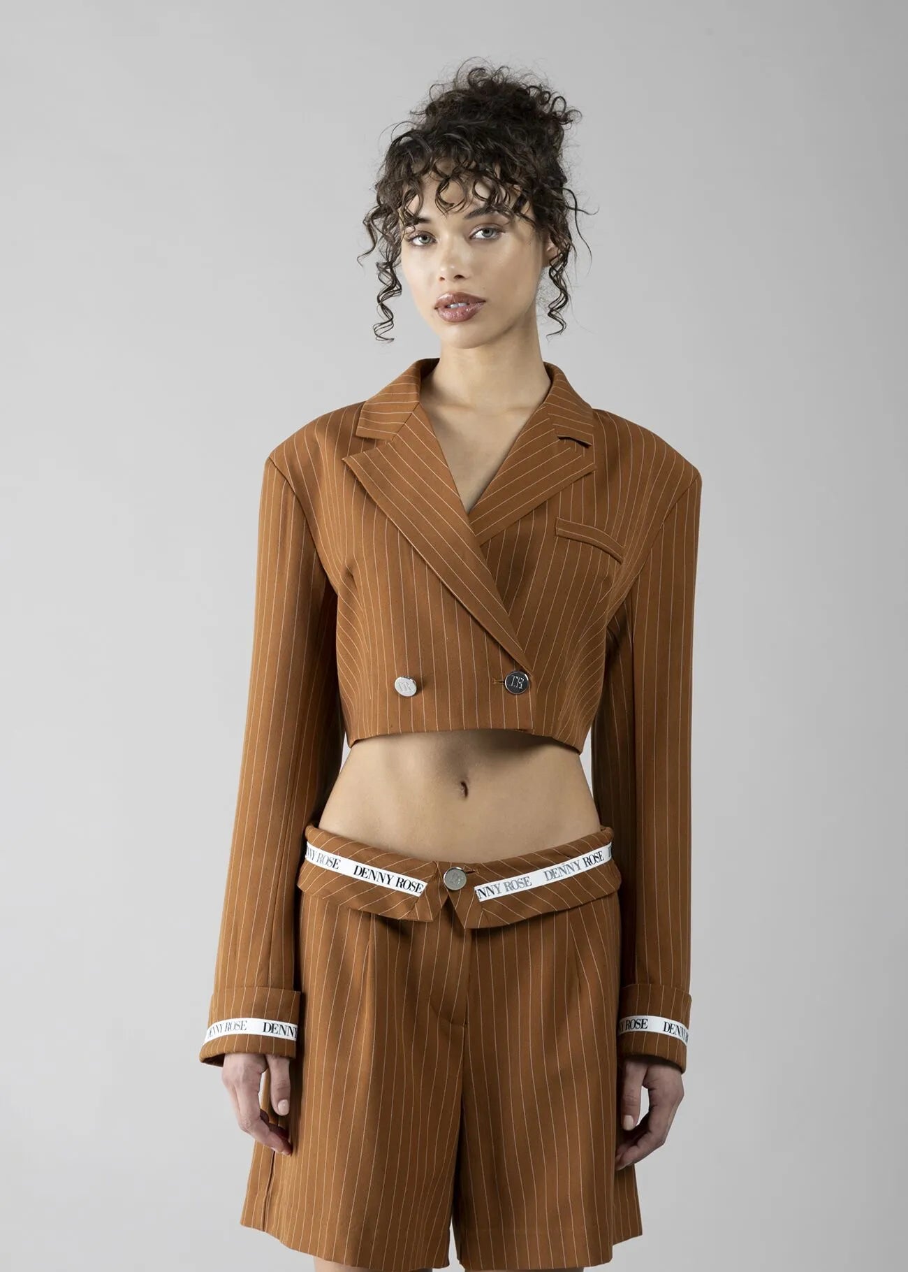 Foto 2 (frontale): "Blazer crop gessato cuoio Denny Rose - vista frontale su modella con doppio petto bottoni logo e revers ampio"