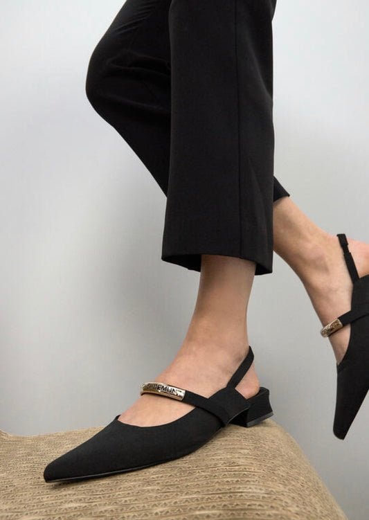 Slingback nere Lola Casademunt con punta a spillo e cinturino con placca logo dorata, vista laterale"