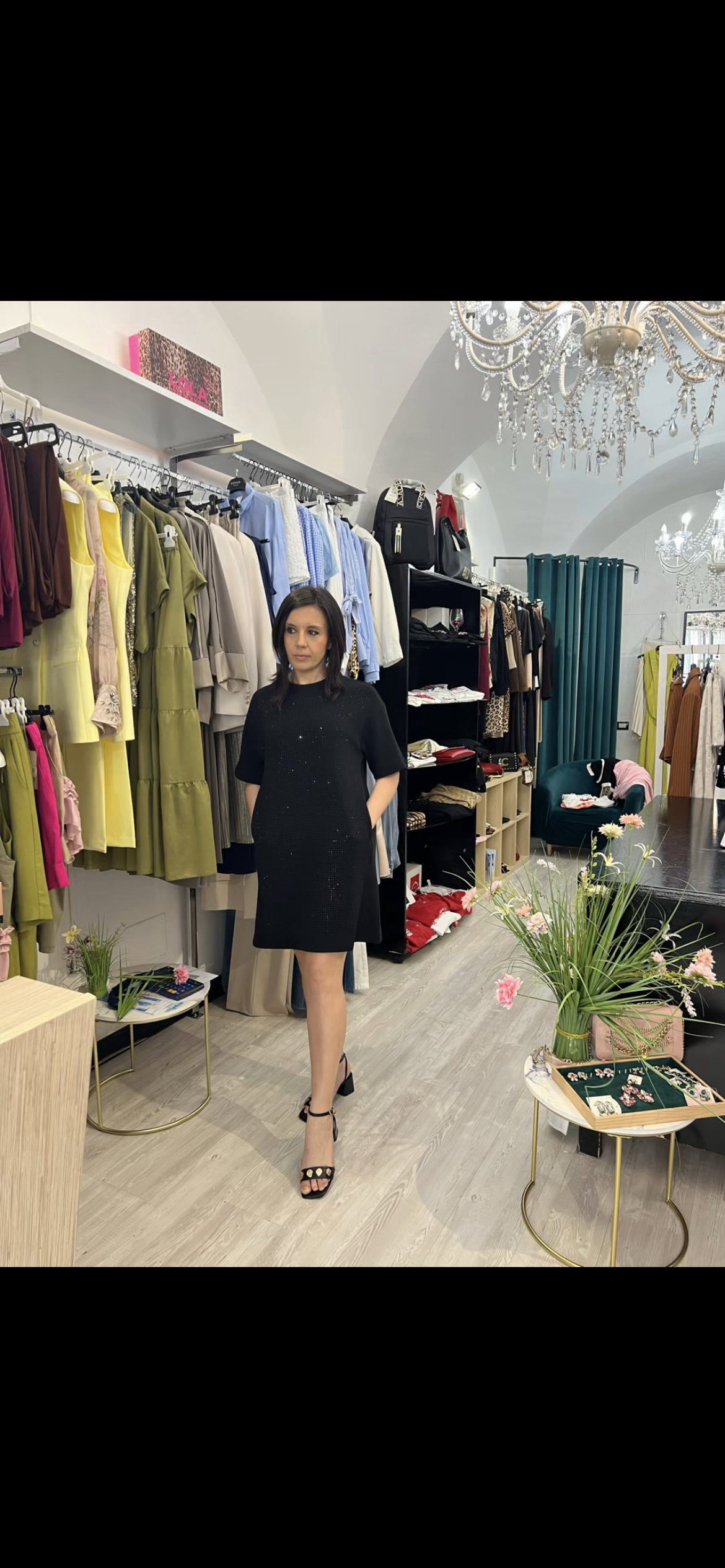 Abito nero Lola Casademunt modello sacchetto con punti luce ton sur ton e tasche, indossato in boutique