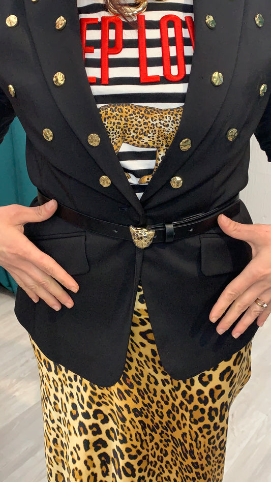 Dettaglio blazer nero con bottoni oro, mix casual-chic.
