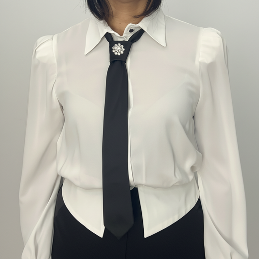 Vista frontale della camicia bianca da donna con cravatta nera e spilla gioiello