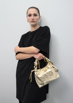 Donna con mini bag dorata Lola Casademunt a tracolla - look serale elegante
